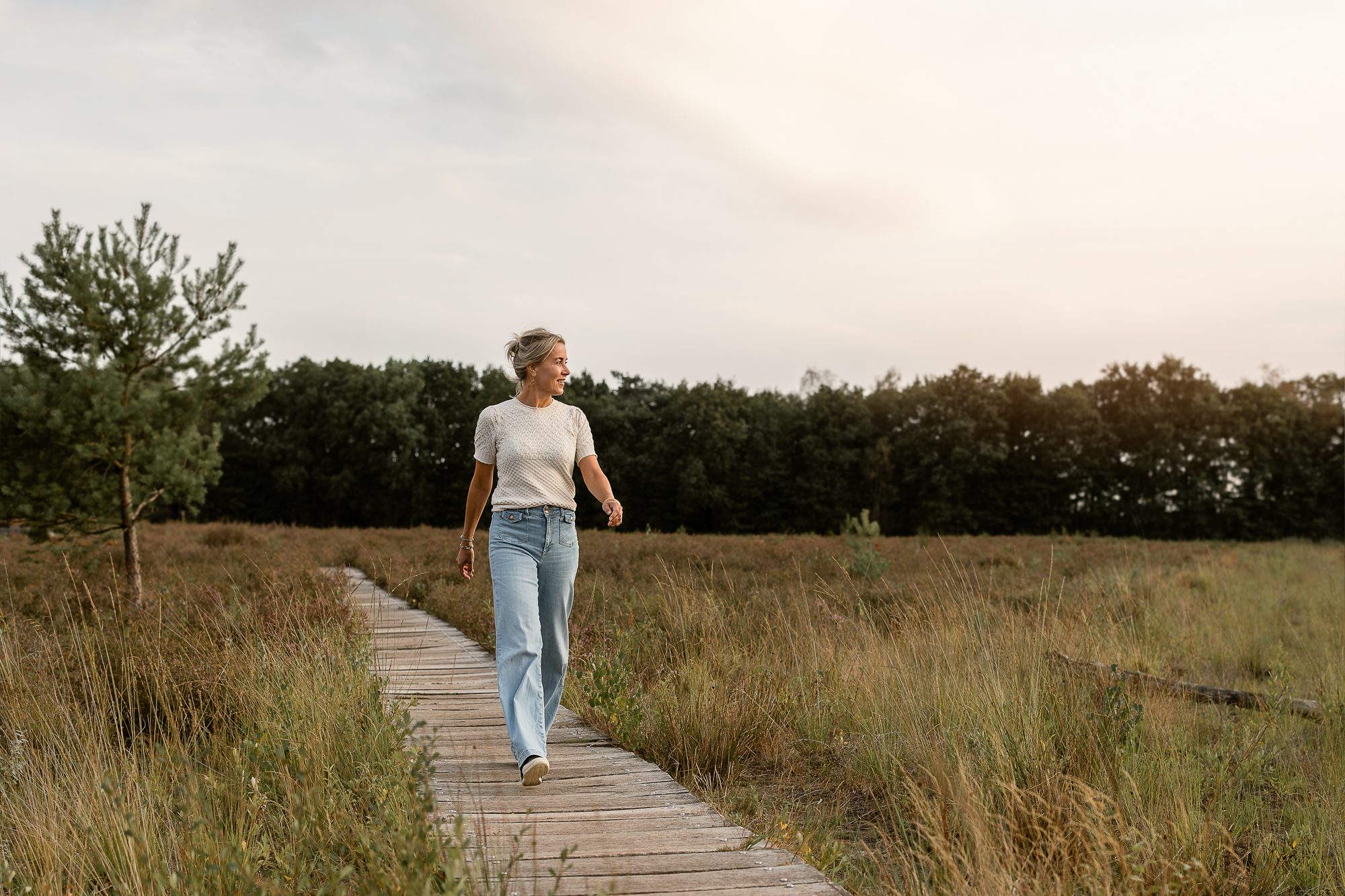 Mariëlle wandelt over een vlonderpad op de heide