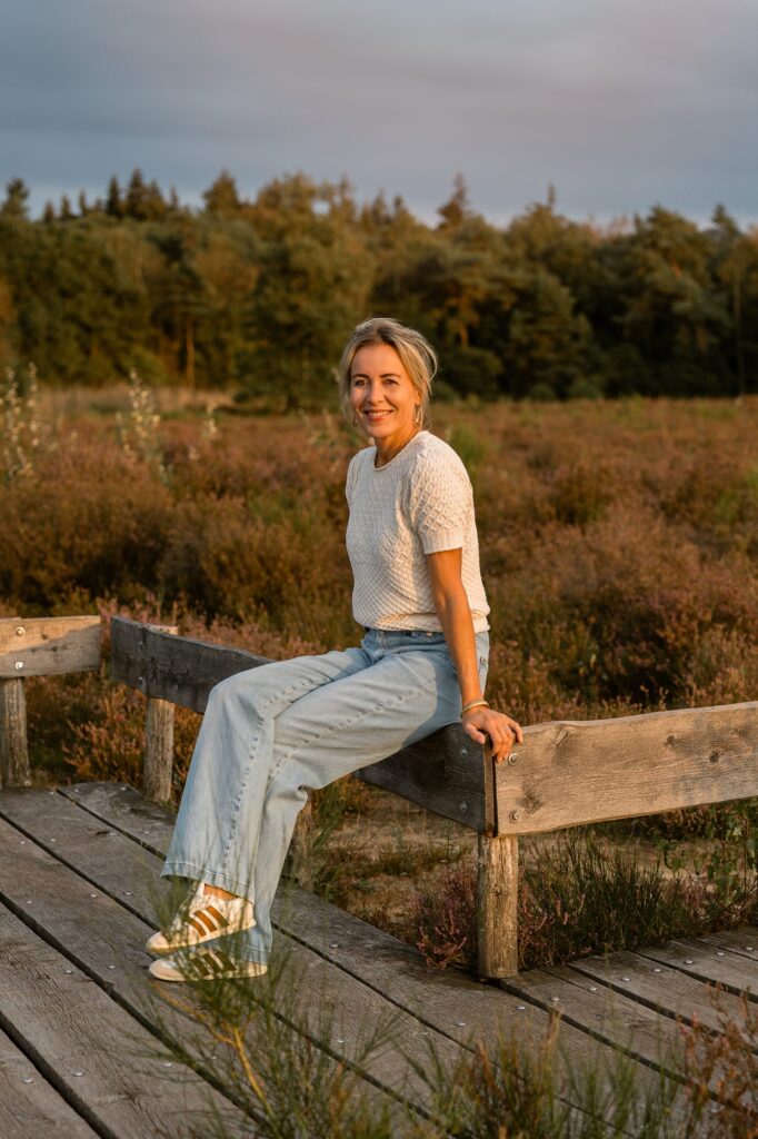 Mariëlle zit op een houten hekje bij het vlonderpad