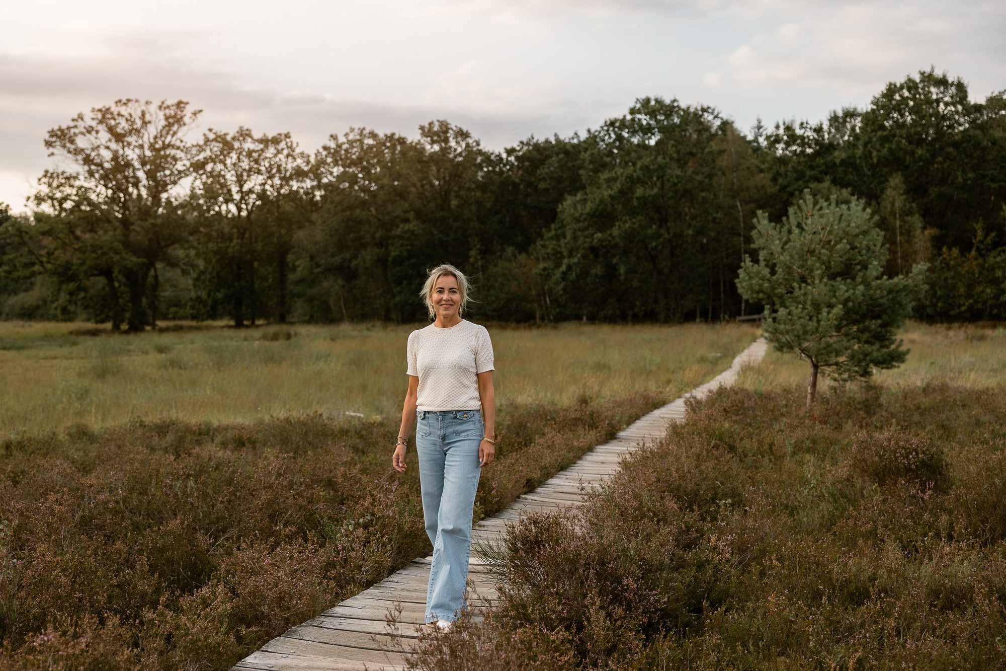Mariëlle wandelt over het vlonderpad langs de bomen